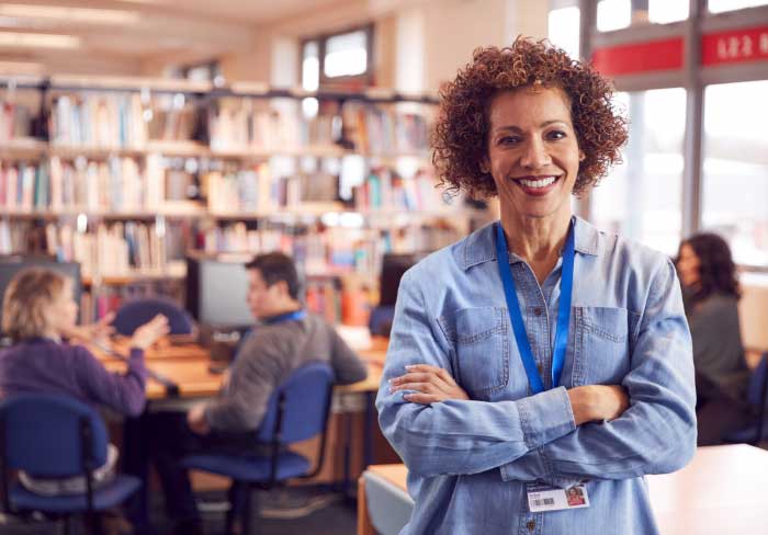 Female special education administrator in a library with students sitting in the background